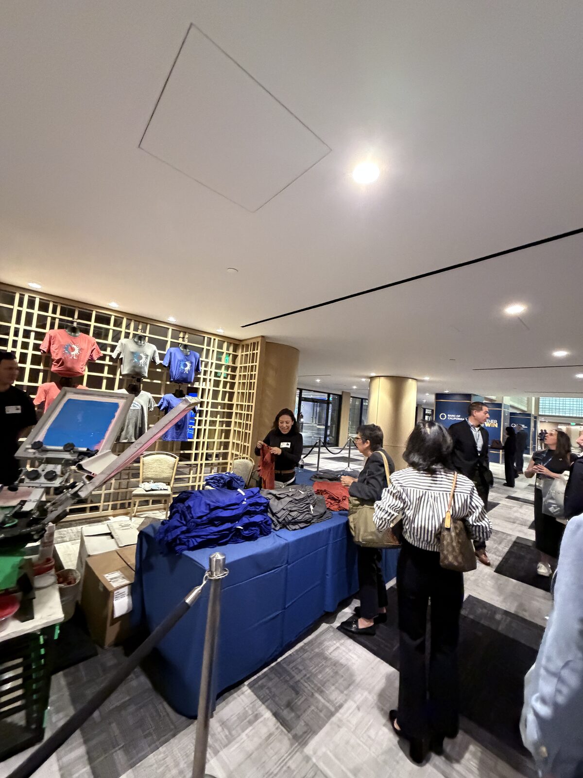Guest receiving a just-printed shirt at an event t-shirt bar