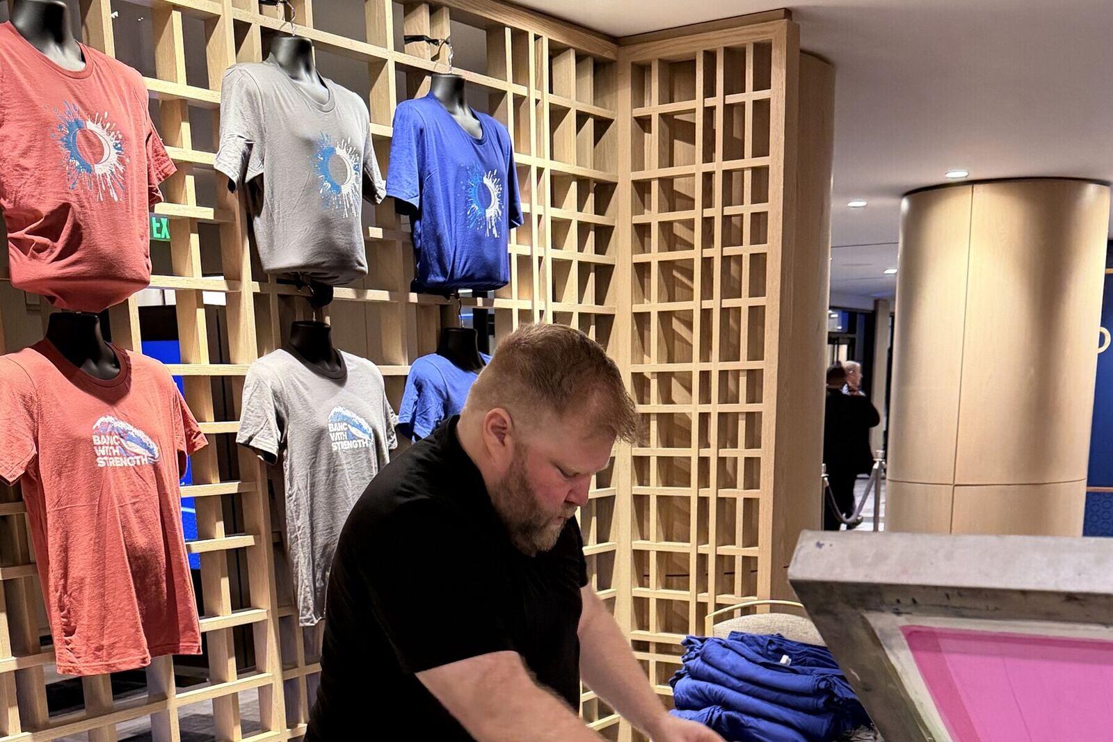 Printed shirts displayed at an event merch table