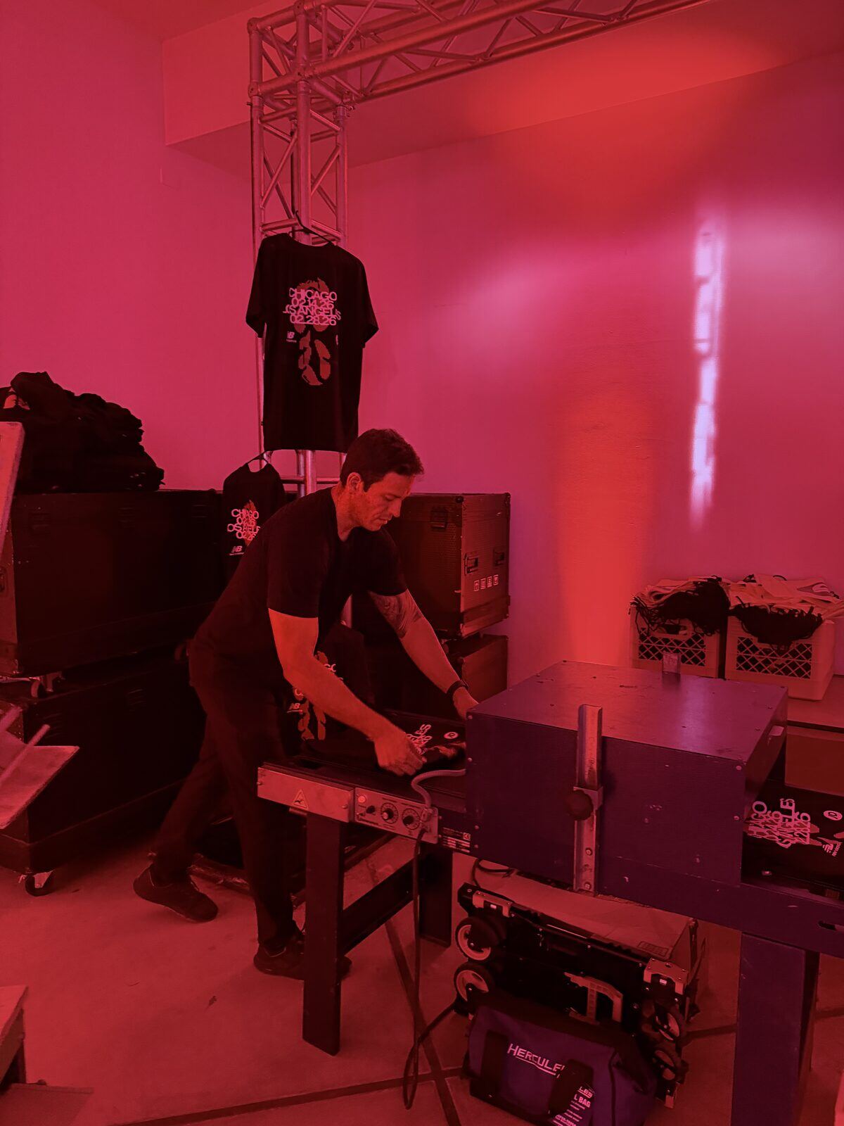 Merch Troop operator pressing a freshly printed shirt at a live t-shirt bar