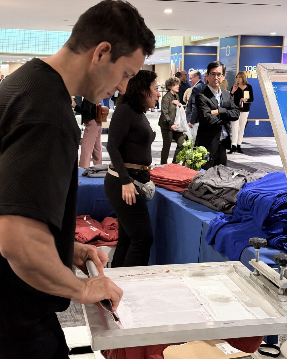 Peeling a fresh print off a shirt at a t-shirt bar
