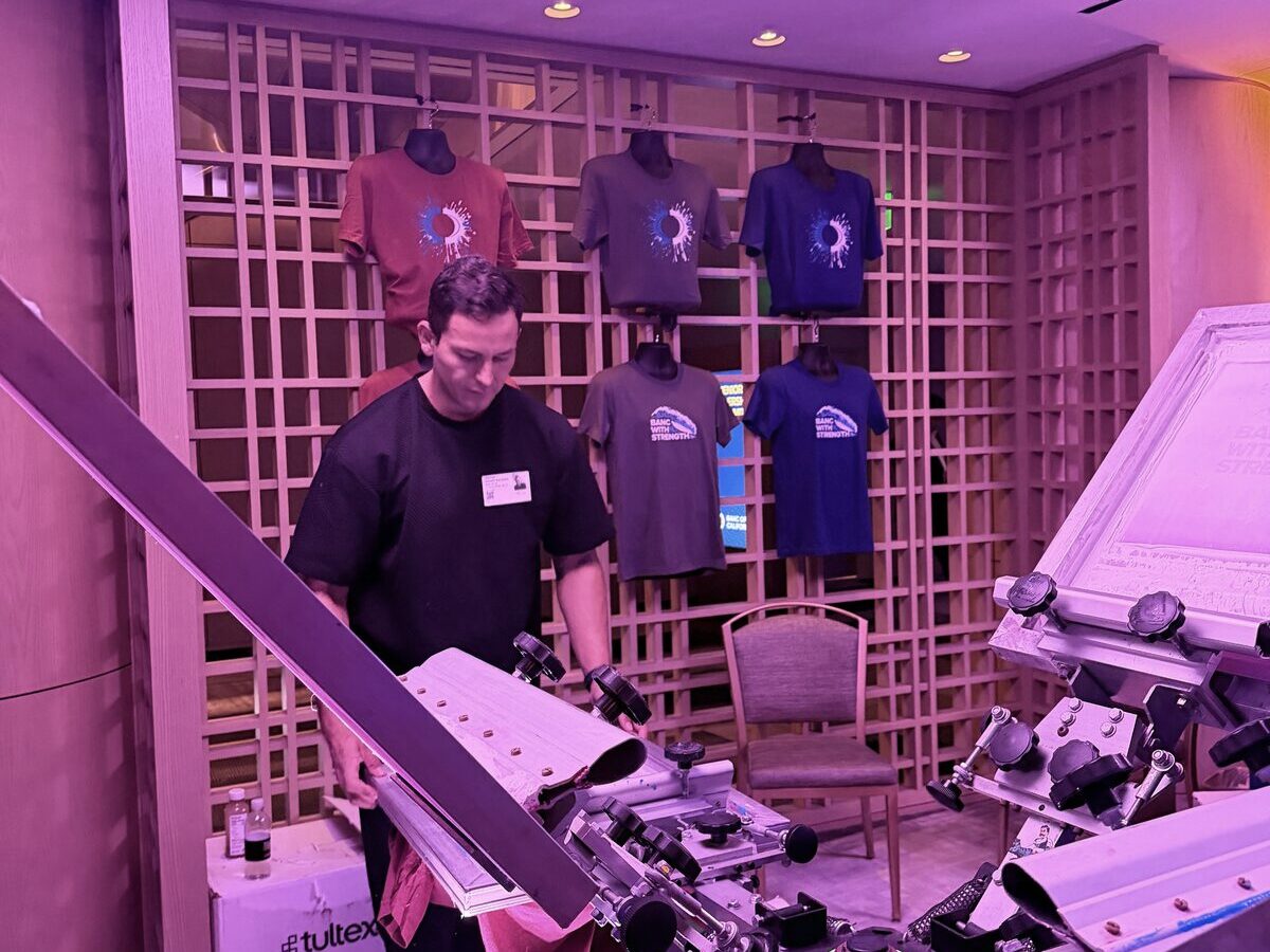 Rented t-shirt bar station stacked with folded blank tees ready to print